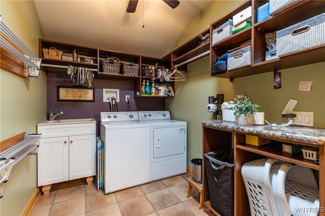 clothes washing area with sink, cabinets, washing machine and clothes dryer, light tile patterned floors, and ceiling fan