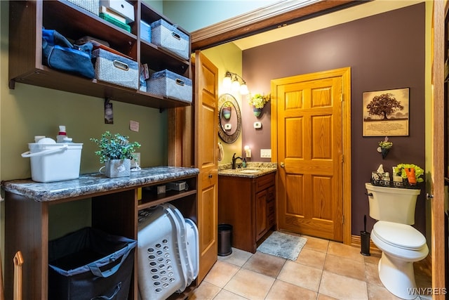 bathroom with toilet, vanity, and tile patterned floors