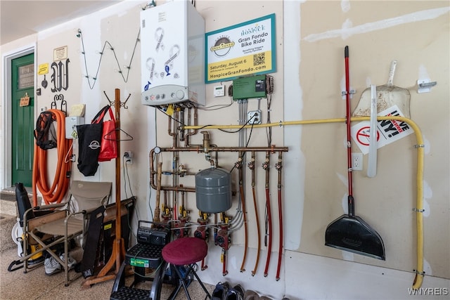 utility room with tankless water heater and water heater