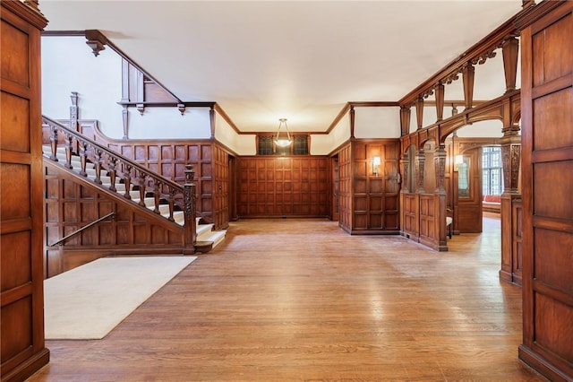 935 E Ave, Rochester, NY 14607 - entryway featuring light wood-style flooring, ornamental molding, a decorative wall, and stairs