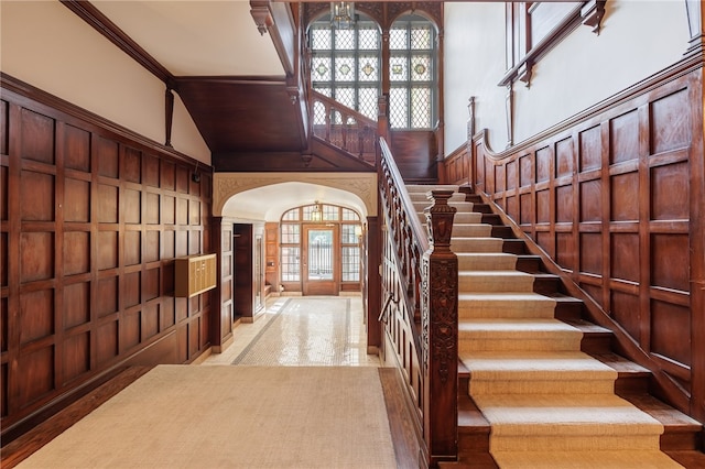 stairway featuring ornamental molding, french doors, and a towering ceiling