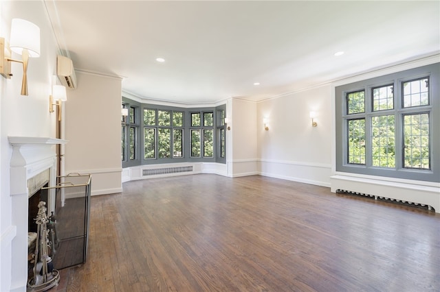 unfurnished living room featuring ornamental molding, an AC wall unit, and dark wood-type flooring