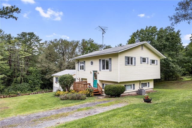 split foyer home featuring a wooden deck, cooling unit, and a front yard