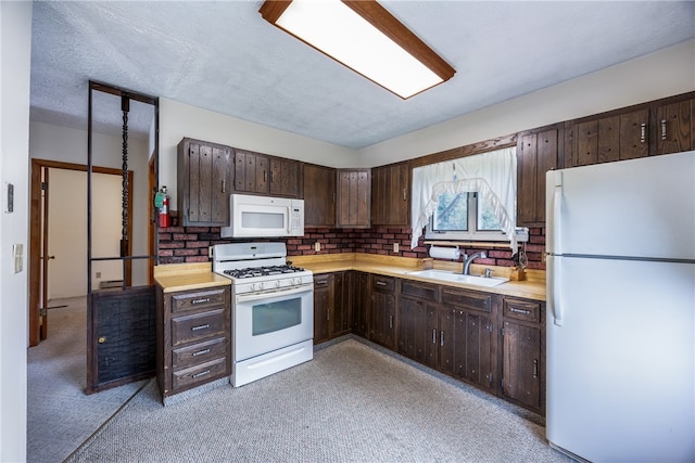 kitchen with sink, white appliances, light carpet, and dark brown cabinets