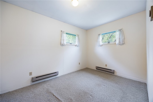 carpeted spare room with a healthy amount of sunlight and baseboard heating