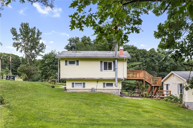 rear view of property featuring a lawn and a deck