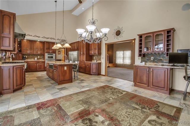 kitchen featuring a chandelier, sink, a center island with sink, light tile patterned floors, and a kitchen breakfast bar