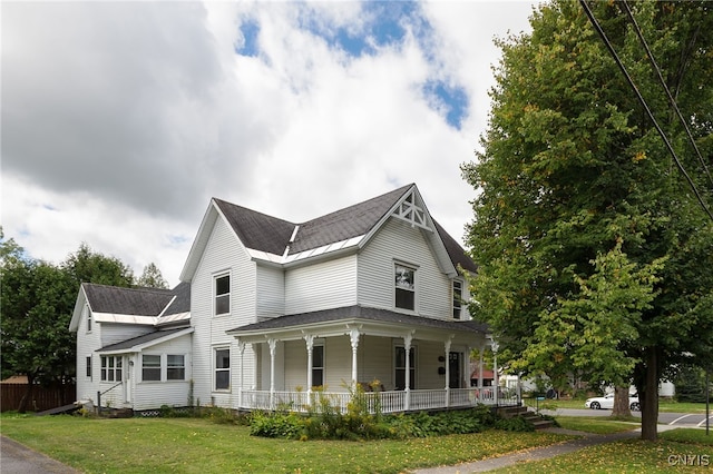 view of front of house with covered porch and a front yard