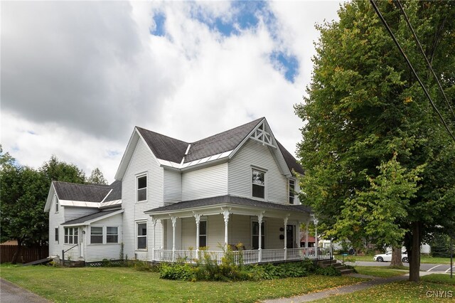 view of home's exterior featuring a porch and a lawn