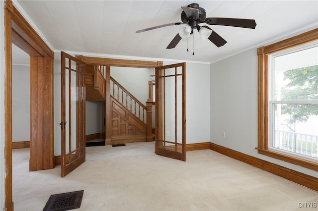 spare room featuring crown molding, visible vents, carpet flooring, baseboards, and stairs