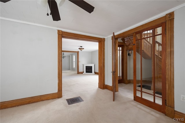 empty room featuring carpet, a fireplace, visible vents, and crown molding