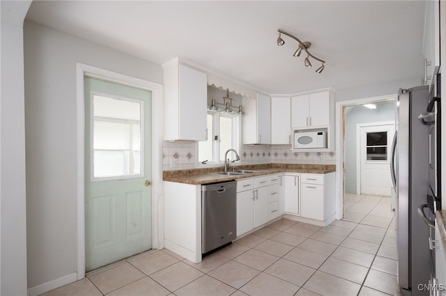 kitchen with white cabinetry, light tile patterned floors, tasteful backsplash, and appliances with stainless steel finishes