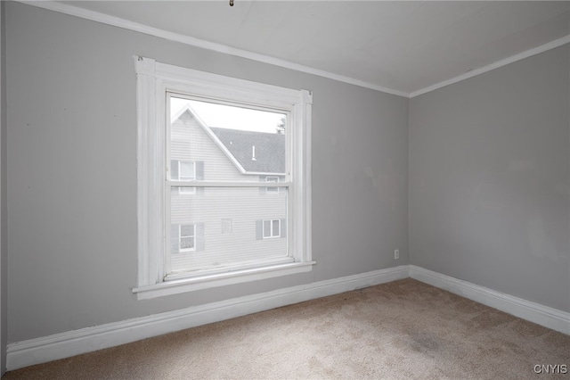 unfurnished room with carpet floors, ornamental molding, and baseboards