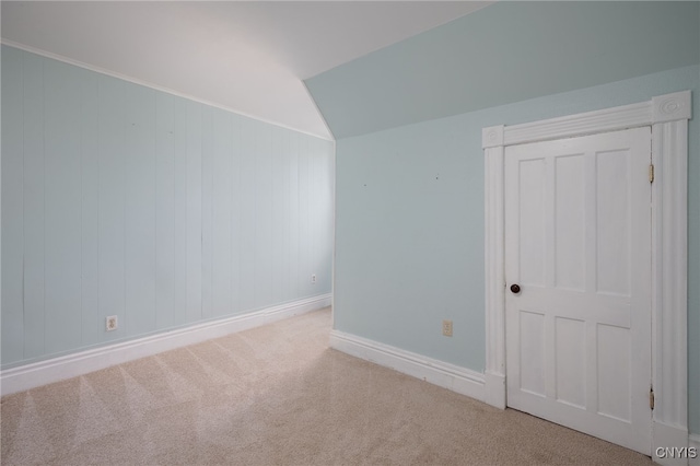 spare room with lofted ceiling, baseboards, and carpet flooring