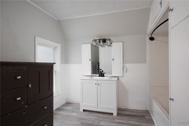 full bathroom with lofted ceiling, wood finished floors, vanity, a bath, and walk in shower