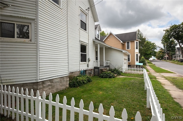 view of side of home featuring a yard and a fenced front yard