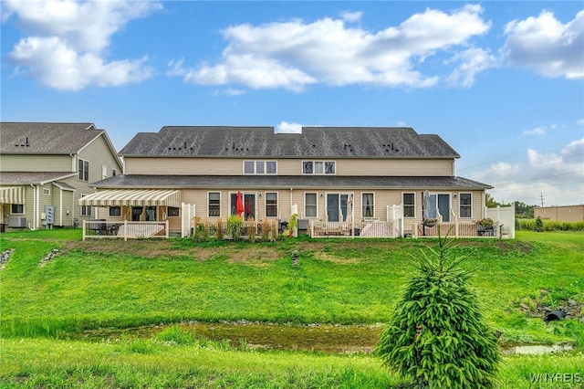 back of house with a wooden deck and a lawn