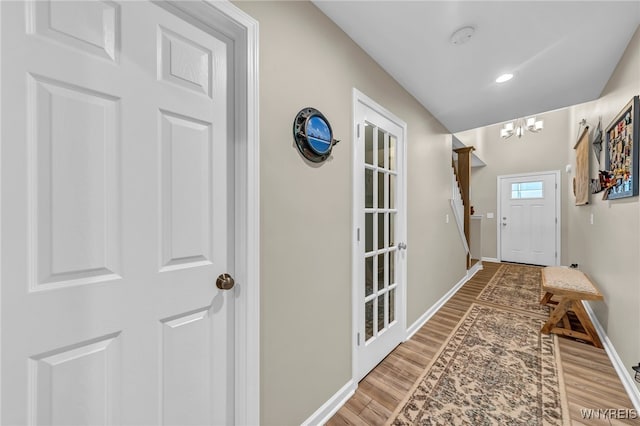 entryway with wood-type flooring and a notable chandelier