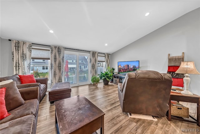 living room featuring lofted ceiling and light hardwood / wood-style floors