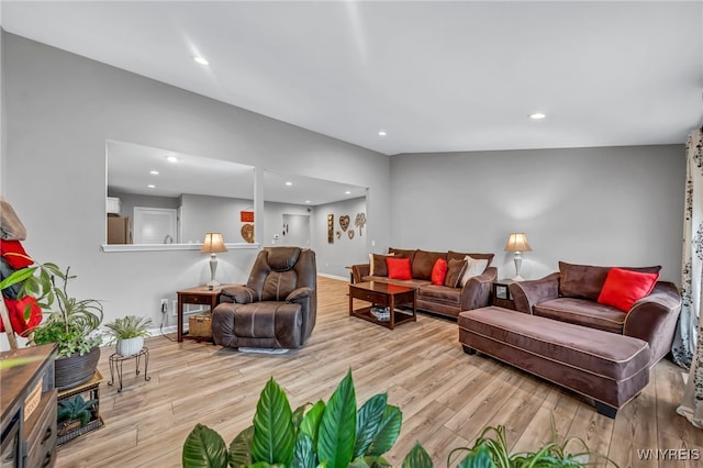 living room featuring light hardwood / wood-style floors and vaulted ceiling