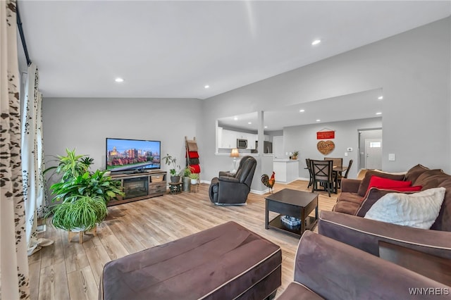 living room with lofted ceiling and light hardwood / wood-style flooring