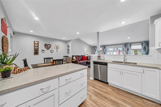 kitchen with light hardwood / wood-style flooring, white cabinets, sink, and stainless steel dishwasher