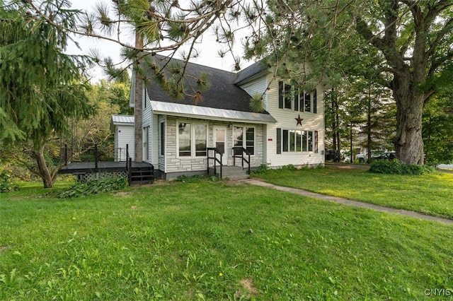 rear view of property featuring a lawn