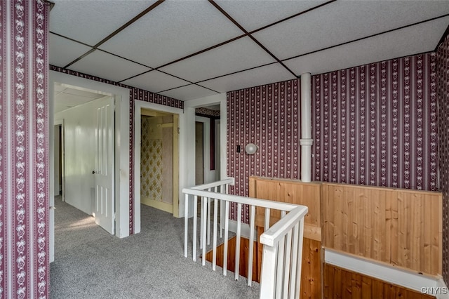 hallway featuring carpet floors and a drop ceiling