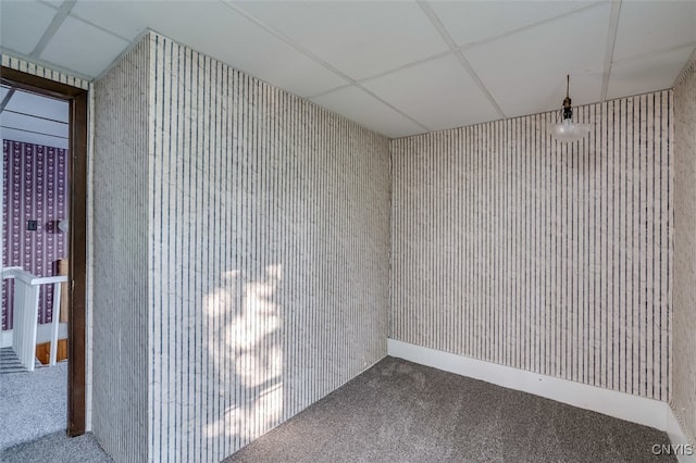 spare room featuring a paneled ceiling and carpet flooring