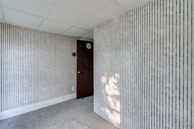 carpeted empty room featuring a paneled ceiling