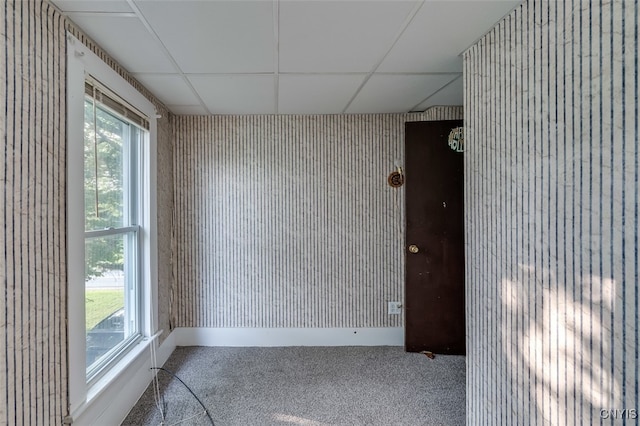 empty room with a drop ceiling and plenty of natural light