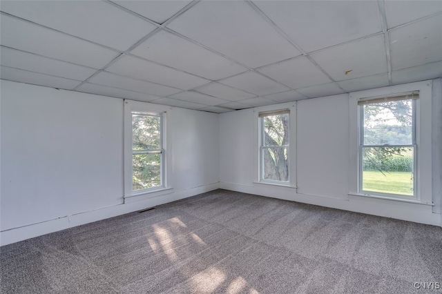 carpeted empty room featuring a paneled ceiling