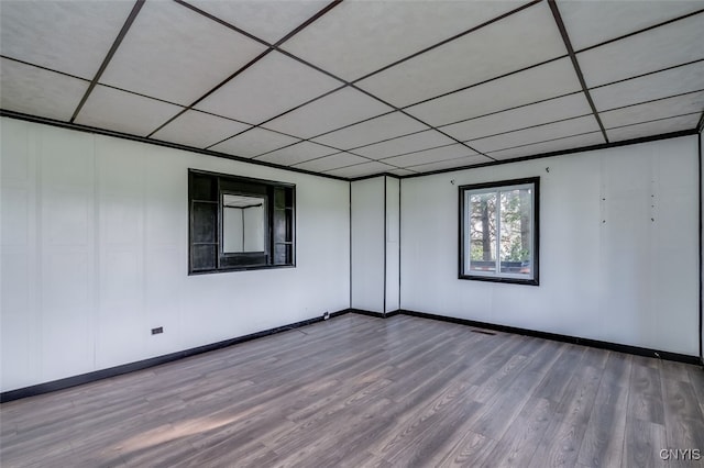 spare room featuring a paneled ceiling and hardwood / wood-style flooring