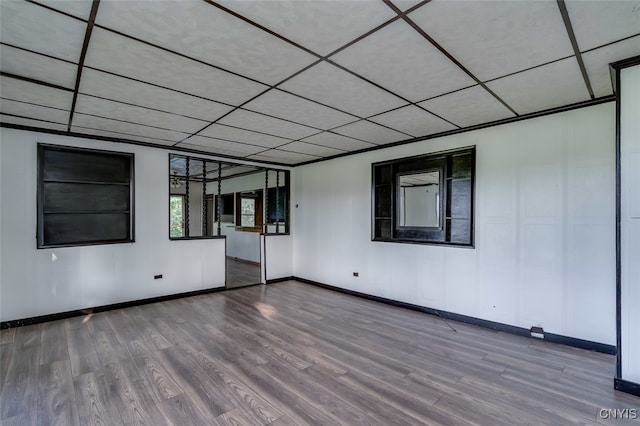 unfurnished room featuring hardwood / wood-style flooring and a paneled ceiling