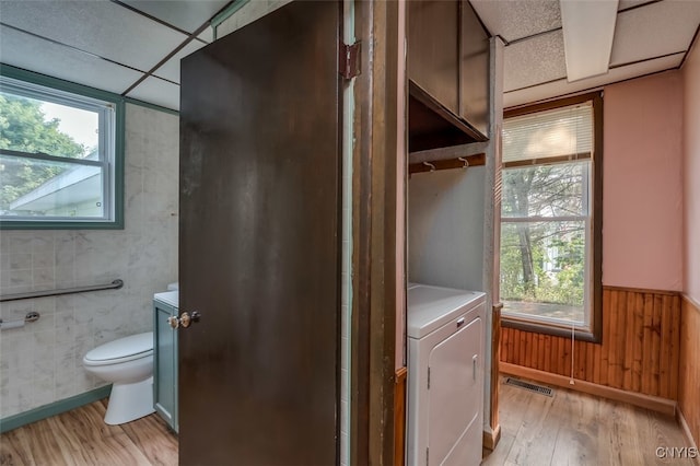 laundry area featuring washer / clothes dryer, light hardwood / wood-style flooring, and a healthy amount of sunlight