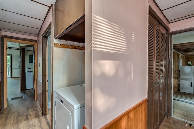 laundry room with washer / clothes dryer, wood-type flooring, and cabinets