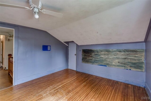 additional living space with hardwood / wood-style floors, vaulted ceiling, and ceiling fan