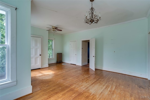 unfurnished living room with crown molding, ceiling fan with notable chandelier, and light wood-type flooring