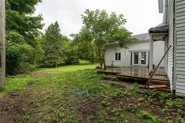 view of yard with a wooden deck and french doors