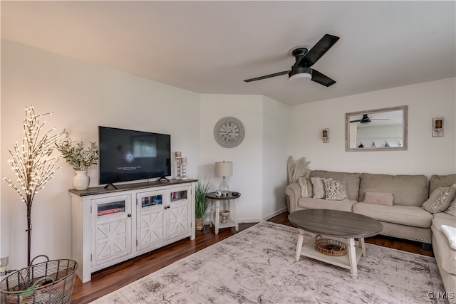 living room featuring ceiling fan and dark hardwood / wood-style flooring