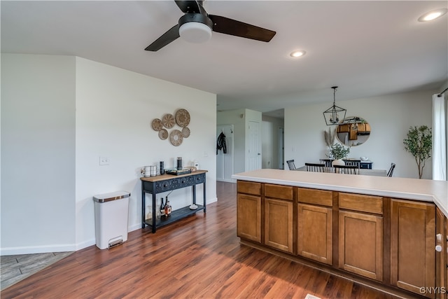 kitchen featuring ceiling fan, hanging light fixtures, and dark hardwood / wood-style floors