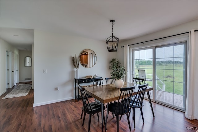 dining room with an inviting chandelier and dark wood-type flooring