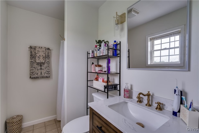 bathroom with toilet, vanity, and tile patterned floors