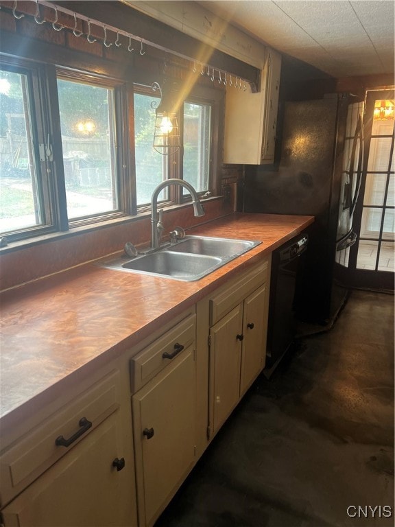 kitchen with dishwasher, plenty of natural light, sink, and cream cabinetry