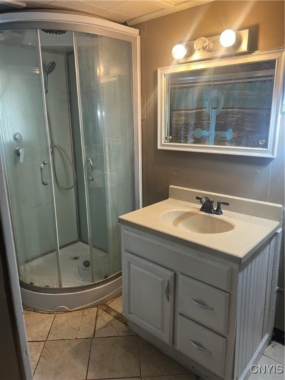 bathroom featuring tile patterned flooring, an enclosed shower, and vanity