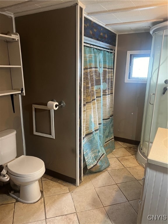 bathroom featuring tile patterned floors, toilet, vanity, and curtained shower