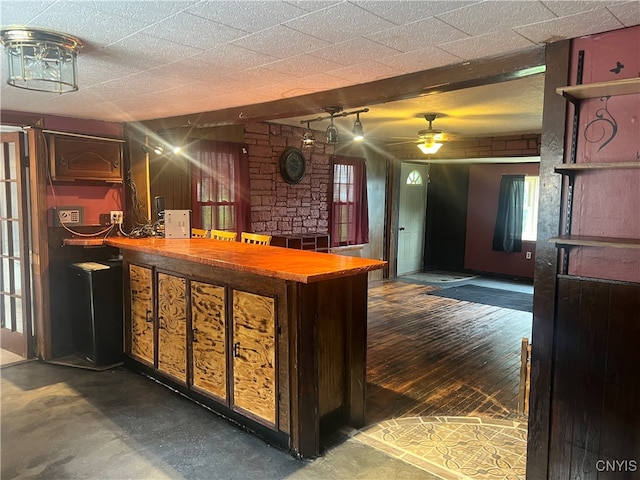 bar with ceiling fan and concrete flooring