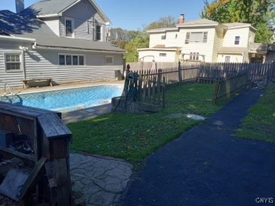 view of swimming pool with a yard