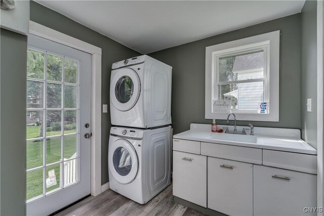 washroom with stacked washer and dryer, plenty of natural light, sink, and hardwood / wood-style floors