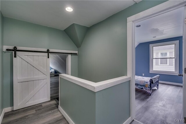 hallway with hardwood / wood-style flooring and a barn door